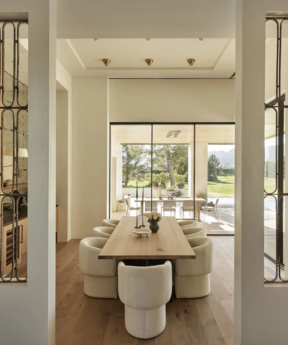 20231102_JennaPeffley_NateBerkus_Romano_0357-min An elegant dining room with a sizable table and multiple dining chairs arranged around it. By one of the best interior designers in the US - Nate Berkus