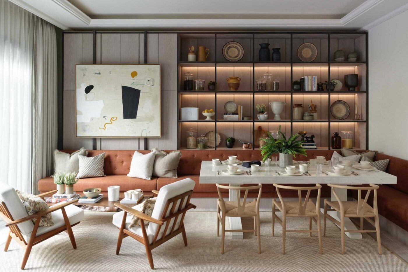 Living room and dining room project by Albion Nord. With neutral and earthy tones and wood accents in the chairs.