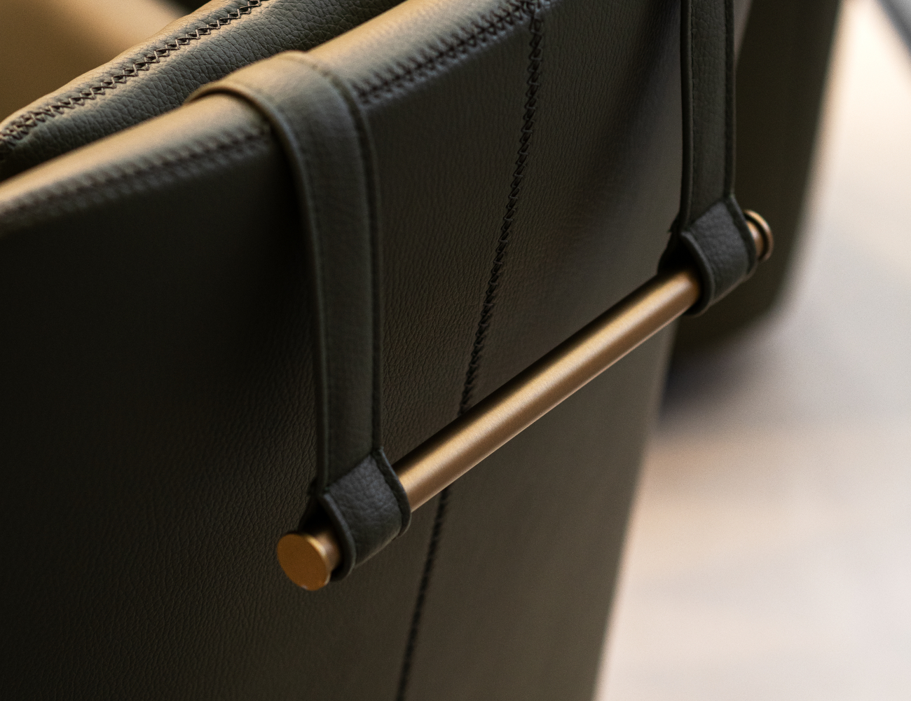 Detailed view of a leather chair showcasing a brass handle, emphasizing the chair's luxurious texture and style. The detail is in brushed metal, one of the trending materials for 2025.