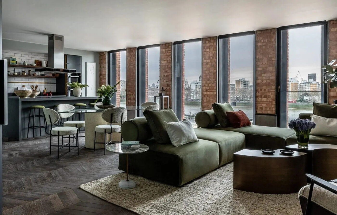 The living room offers a stunning view of the city through expansive windows, highlighting urban architecture. By Michaelis Boyd.