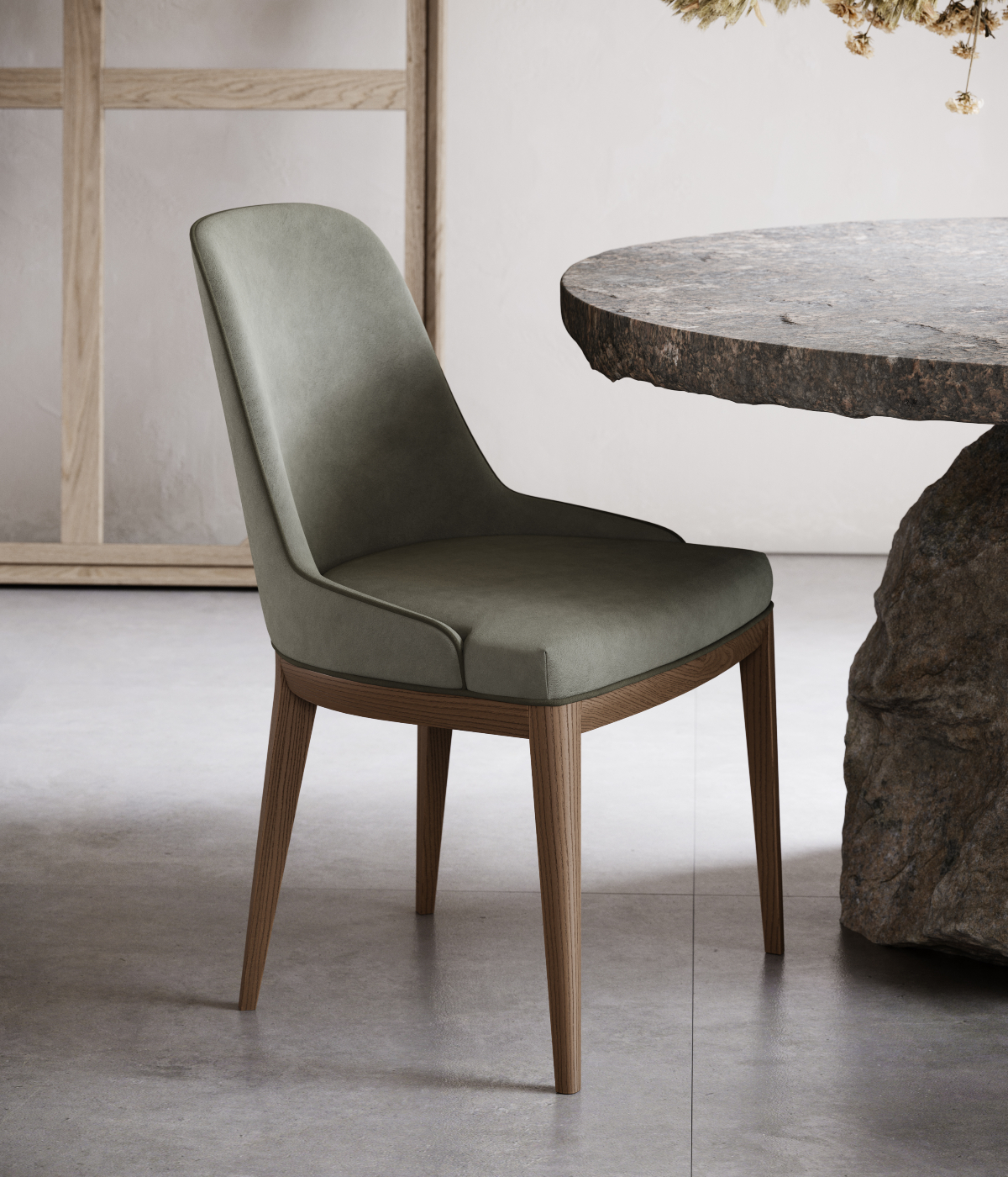 A green-upholstered chair located in front of a stone table, offering a comfortable spot for relaxation or dining.