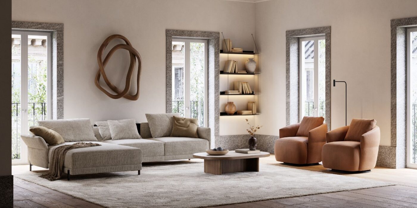 Blog Featured Image - 2026-03-19T174343.638 Modern living room with a beige sectional sofa, two brown armchairs, a round coffee table, and art on the wall. The room is well-lit with natural light.