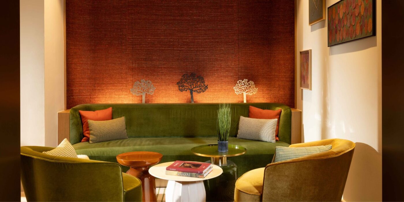 Blog Featured Image - 2026-05-26T151612.700 A green sofa with two armchairs in a well-decorated room, emphasising a modern and comfortable living space. At the Le Cardinal Paris Hotel