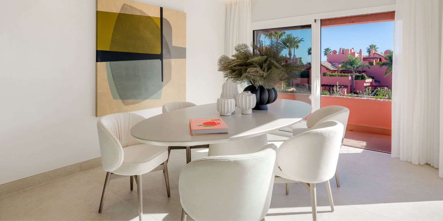 A well-arranged dining table and dining chairs positioned in a room, showcasing a beautiful view through the window.
