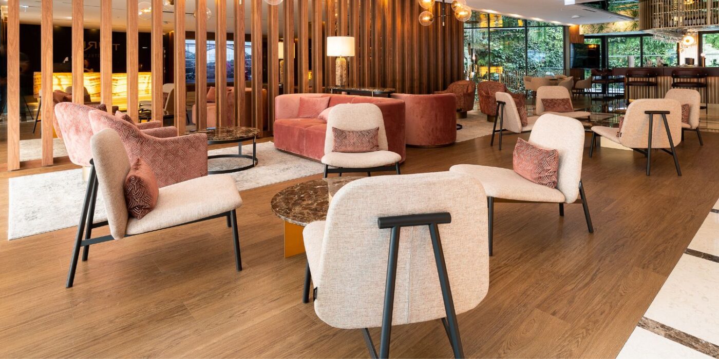 Blog Featured Image - 2026-06-30T175506.643 A modern hotel lobby featuring wooden walls and contemporary chairs, creating a warm and inviting atmosphere.