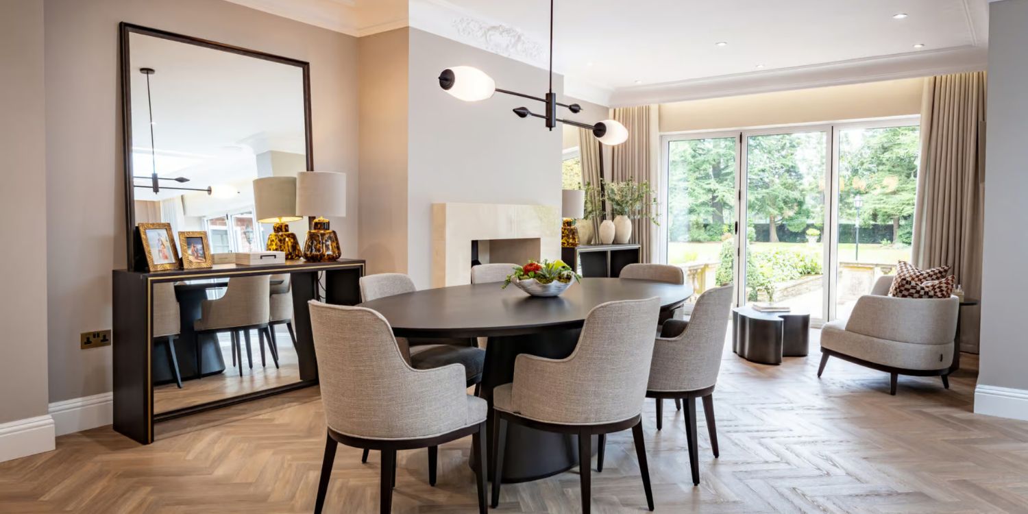 A dining room featuring a table surrounded by dining chairs, creating an inviting space for meals and gatherings. Designed by Rossi Studio