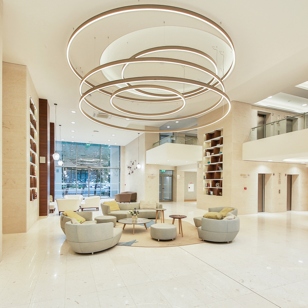 Borella Art Design project. The lobby of an hotel in white tones and grey sofas.