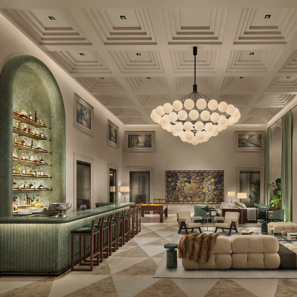 Como1_14a_RGB_V5c_LOBBY-REVISION by edition hotels Elegant lounge with a high ceiling and geometric patterns, featuring a green marble bar, plush seating, and a large modern chandelier, creating a luxurious atmosphere.