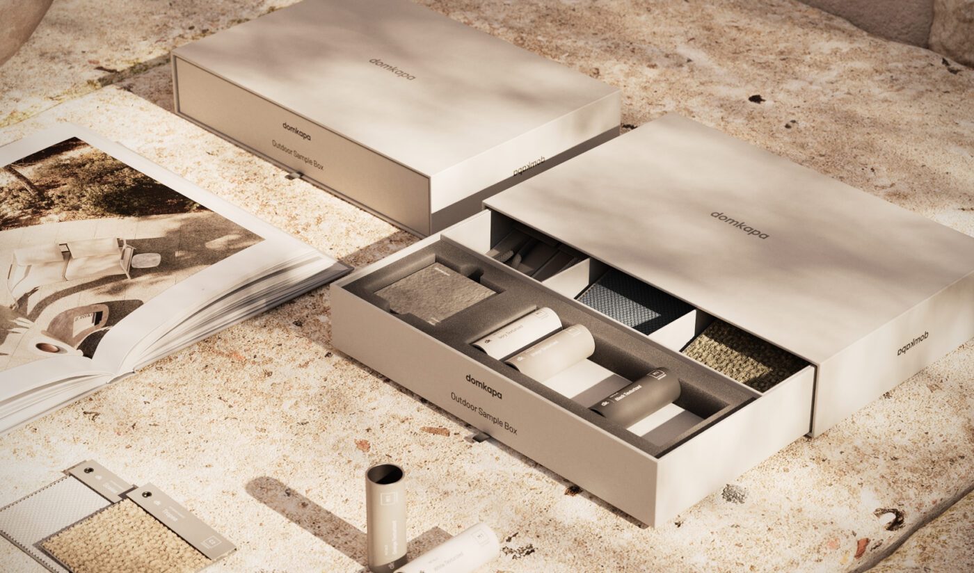 DK26 - SAMPLE BOX OUTDOOR 2026 - 03 - H Elegant packaging of various textured materials in a serene setting. Open box reveals samples and a catalogue, exuding a luxurious and minimalist tone.