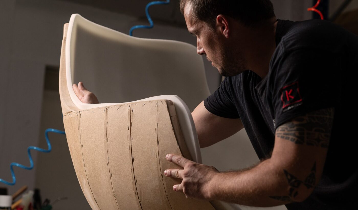 A worker from Domkapa, upholstering an armchair. The craftsmanship will be one of the interior design trends for 2025.