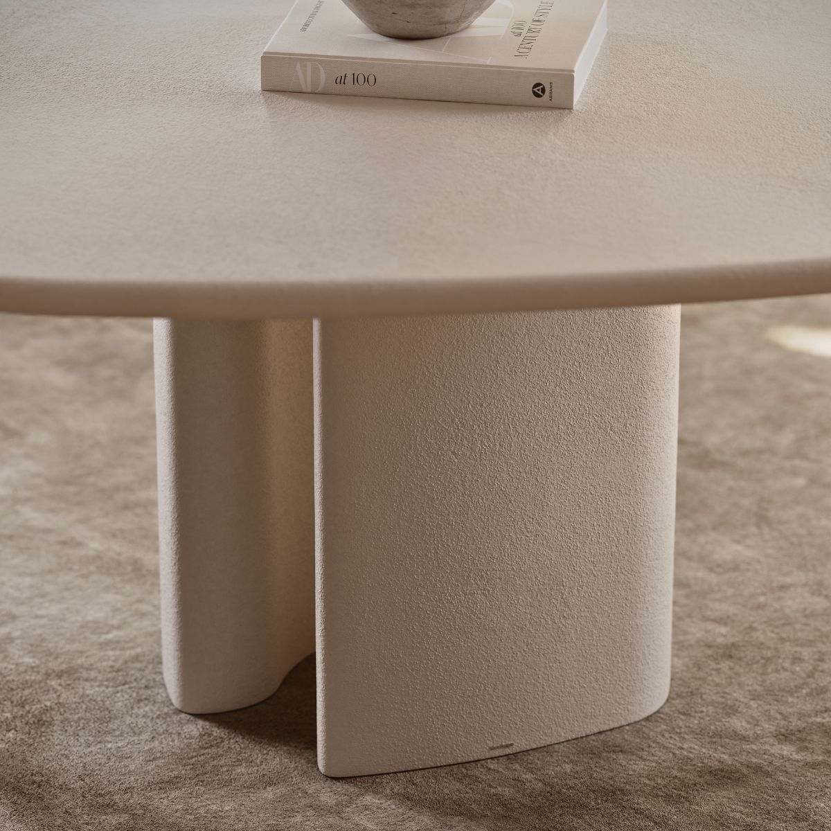 Elodie Dining Table by Domkapa (1) A white table with a closed book resting on its surface, highlighting the tables fluidity.