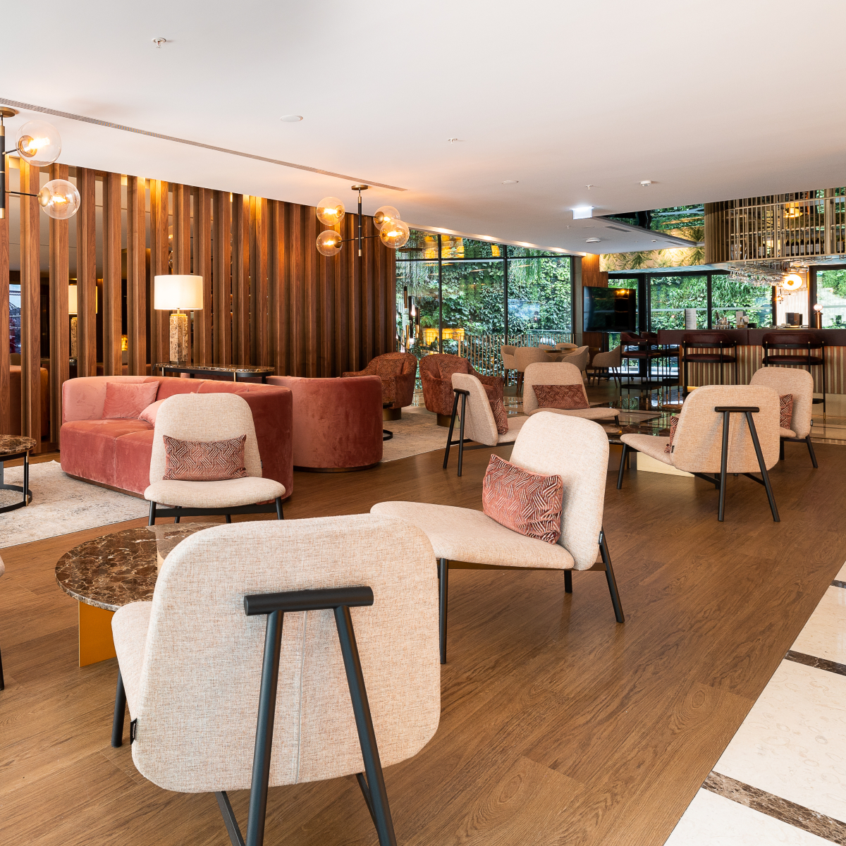 Contemporary hotel lobby with wooden walls and comfortable armchairs, designed for relaxation and socialising. Commercial interior design.