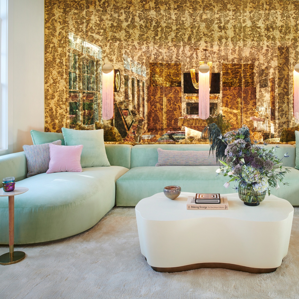 Living room with a sofa in mint green tones and a white coffee table.