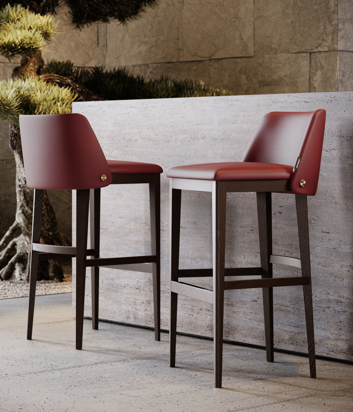 A pair of vibrant red bar stools set against a minimalist concrete wall, enhancing the contemporary decor.