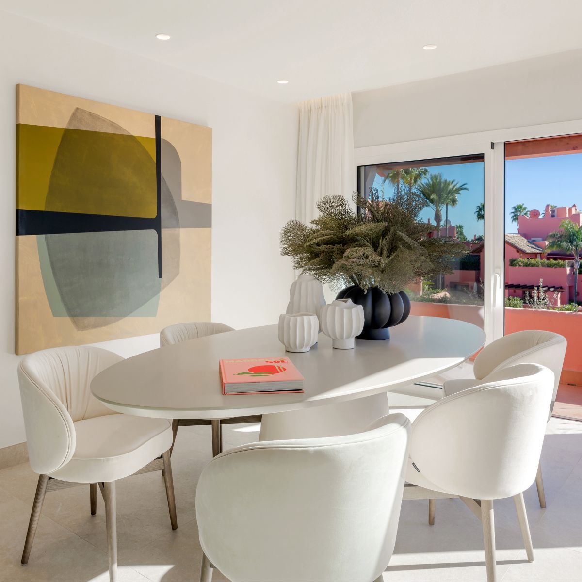 Project with Norah by Maite de la Rosa (1) Bright dining room showcasing white chairs and a prominent large painting, creating a stylish atmosphere.