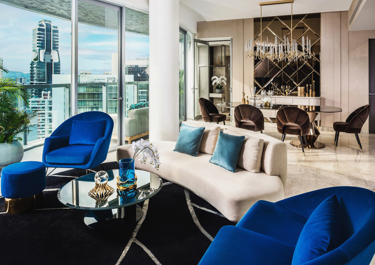 A contemporary asian living room and dining room showcasing blue chairs and a glass table, creating an inviting atmosphere.