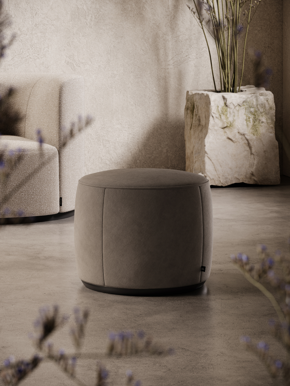 A round pouf in light brown located in front of a wall, serving as a functional and stylish piece of furniture in the space.