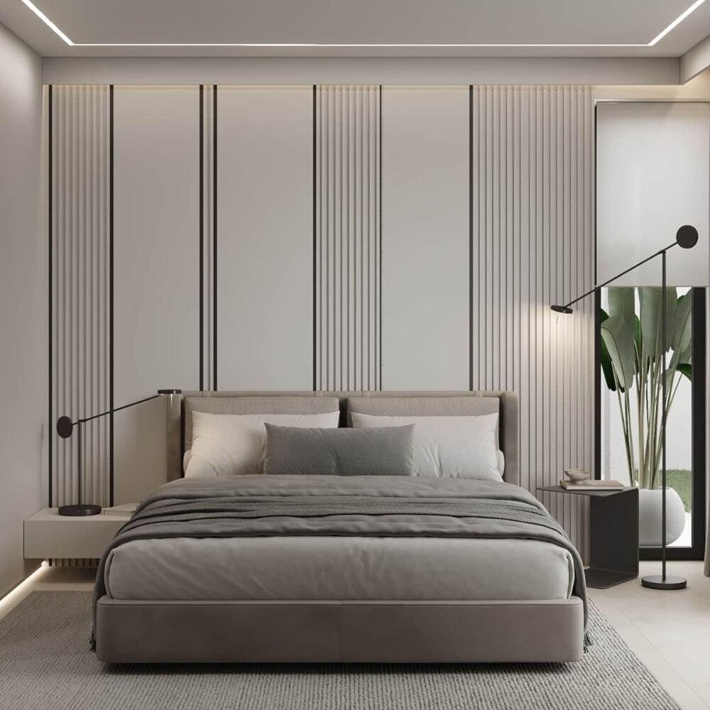 Rental 12 project Azulis Aramis (1) Minimalist bedroom with a gray bed and matching bedding, flanked by sleek black lamps. Vertical striped wall panels add texture. Large potted plant in the corner.