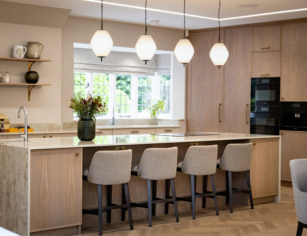 Modern kitchen by Rossi Studio showcasing a large island with counter chairs, creating a welcoming space for cooking and socialising.