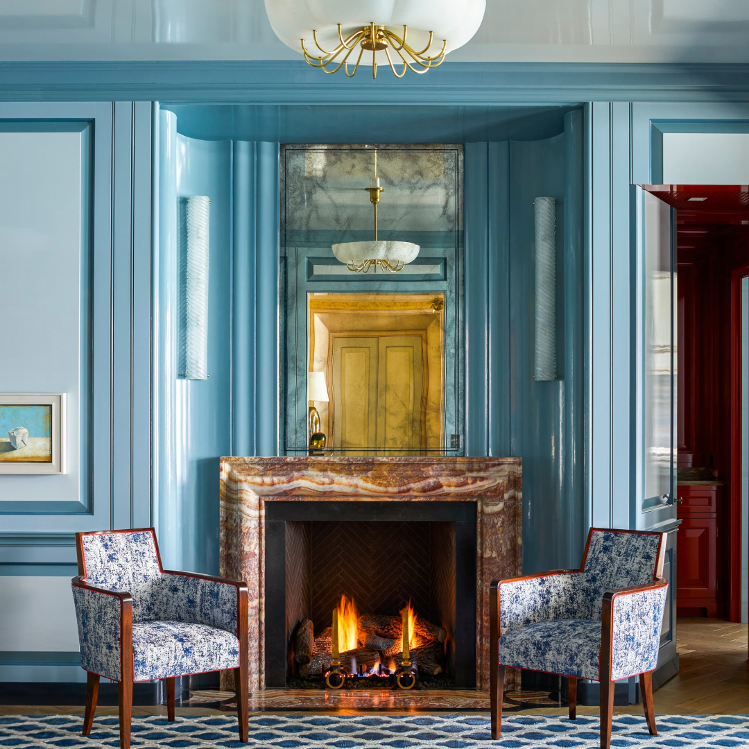 Living room corner in blue tones. With two armchairs in blue tones and floral fabrics. With a fireplace in the middle.