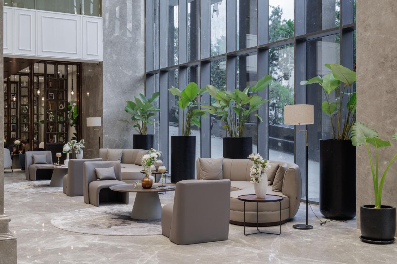 Spacious lobby in a commercial project with big windows letting in light and large plants adding a touch of nature to the decor.