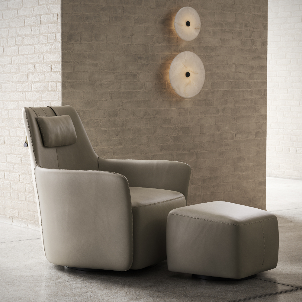 A sleek armchair and ottoman placed before a brick wall, emphasising a modern aesthetic in interior decor.
