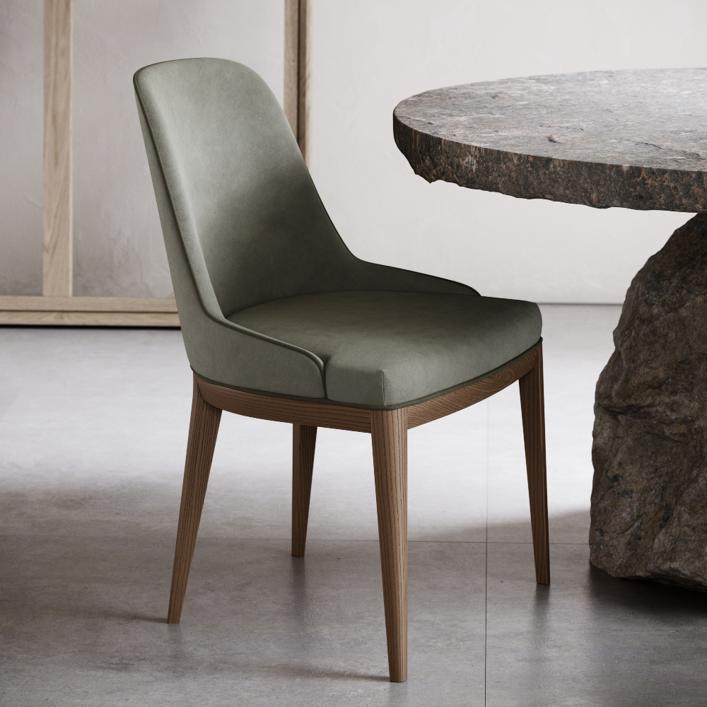 A green upholstered chair is positioned beside a stone table in a cosy home office setting.