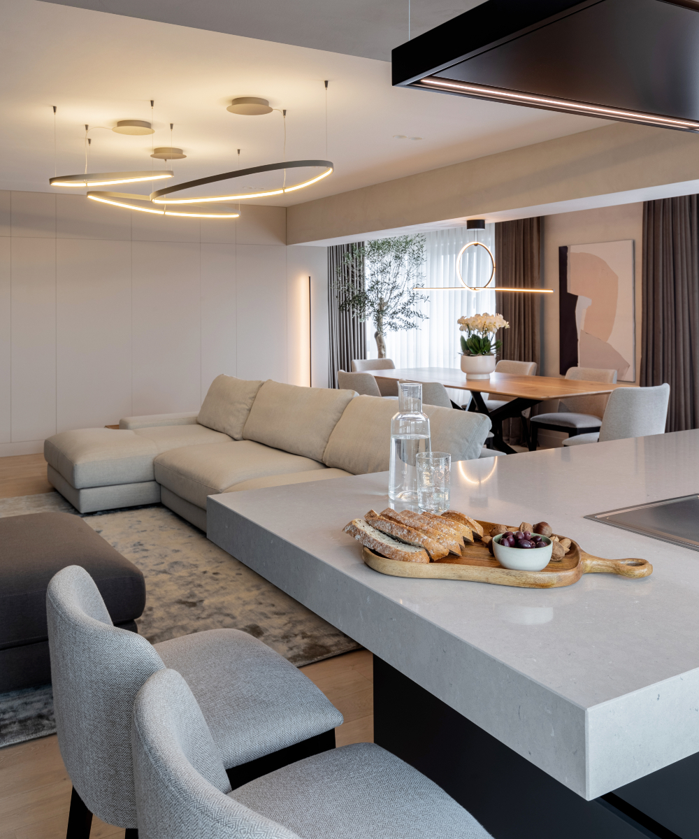 Contemporary kitchen showcasing white countertops and trendy modern lighting.