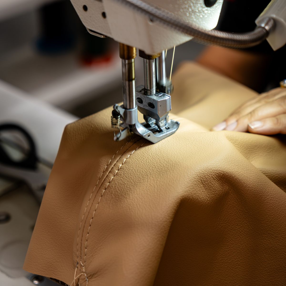 blog article about care & maintenance A person carefully sewing a piece of fabric with a sewing machine, focused on their task. Care & Maintenance