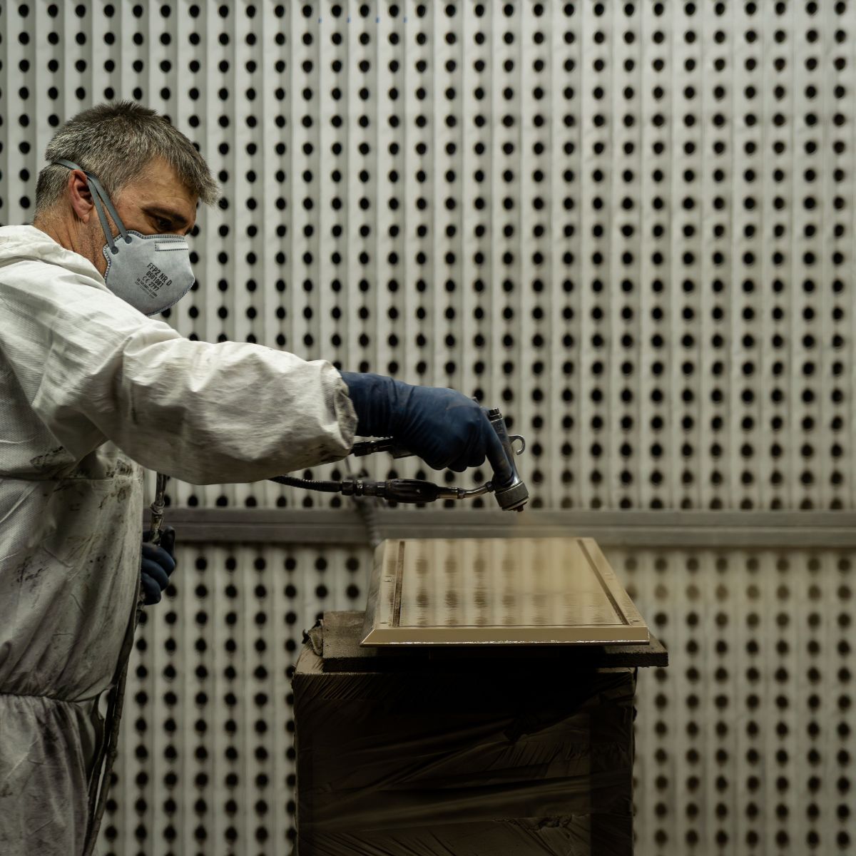 blog article about care & maintenance (3) A man in a white suit is engaged in painting a wooden piece, demonstrating his artistic skills and attention to detail. Care & maintenance