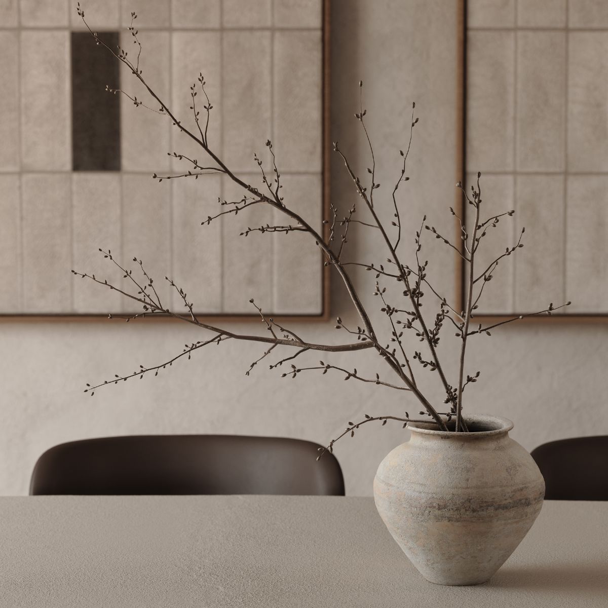 blog article about chocolate brown upholstery by domkapa A vase with a branch is placed on a wooden table, showcasing a simple yet elegant decor arrangement.