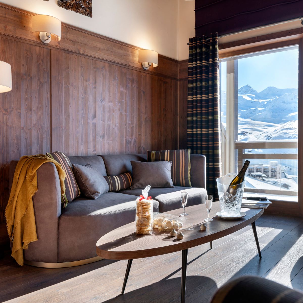 blog article about com vs house fabric by domkapa (4) A cosy living room featuring a Domkapa sofa and coffee table, with a scenic view of mountains through the window.