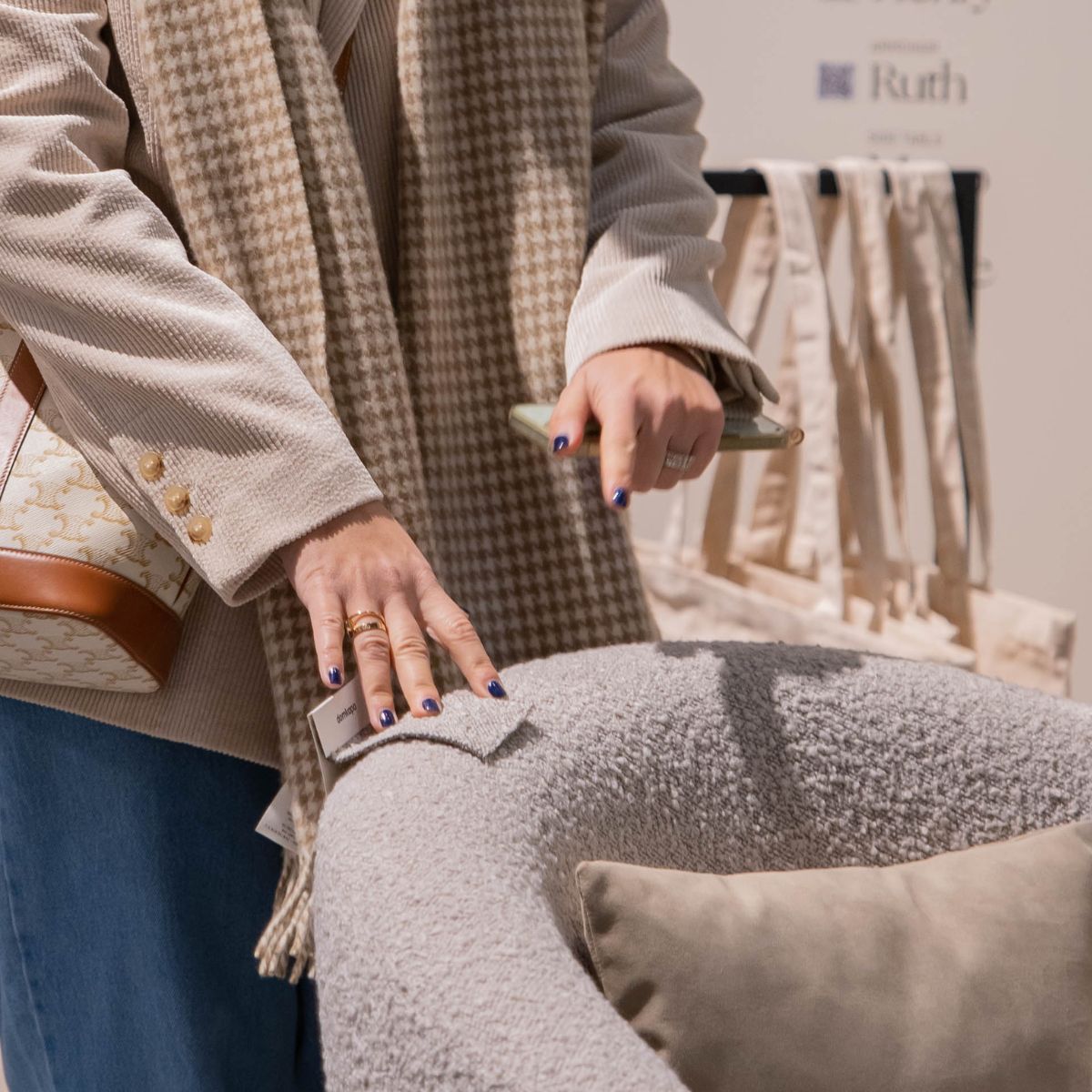 blog article about com vs house fabric by domkapa (6) A woman displays a bag in her hand, highlighting fabric swatch selection for an armchair.