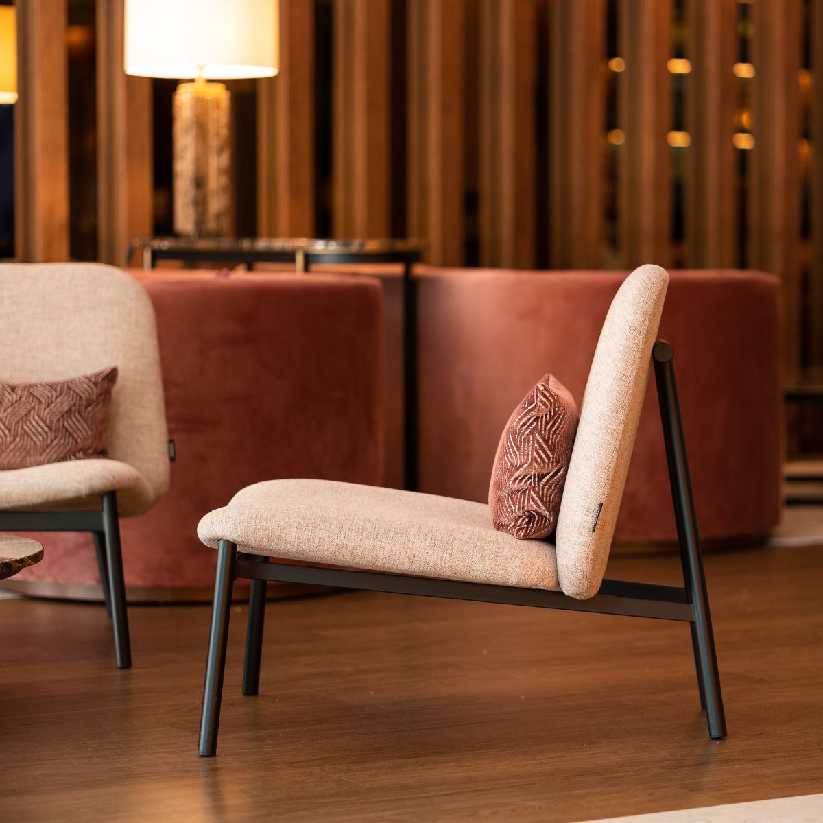 blog article about com vs house fabric by domkapa Interior view of a lounge with two armchairs, a table, and a lamp, suggesting a comfortable seating area. COM vs. house fabric