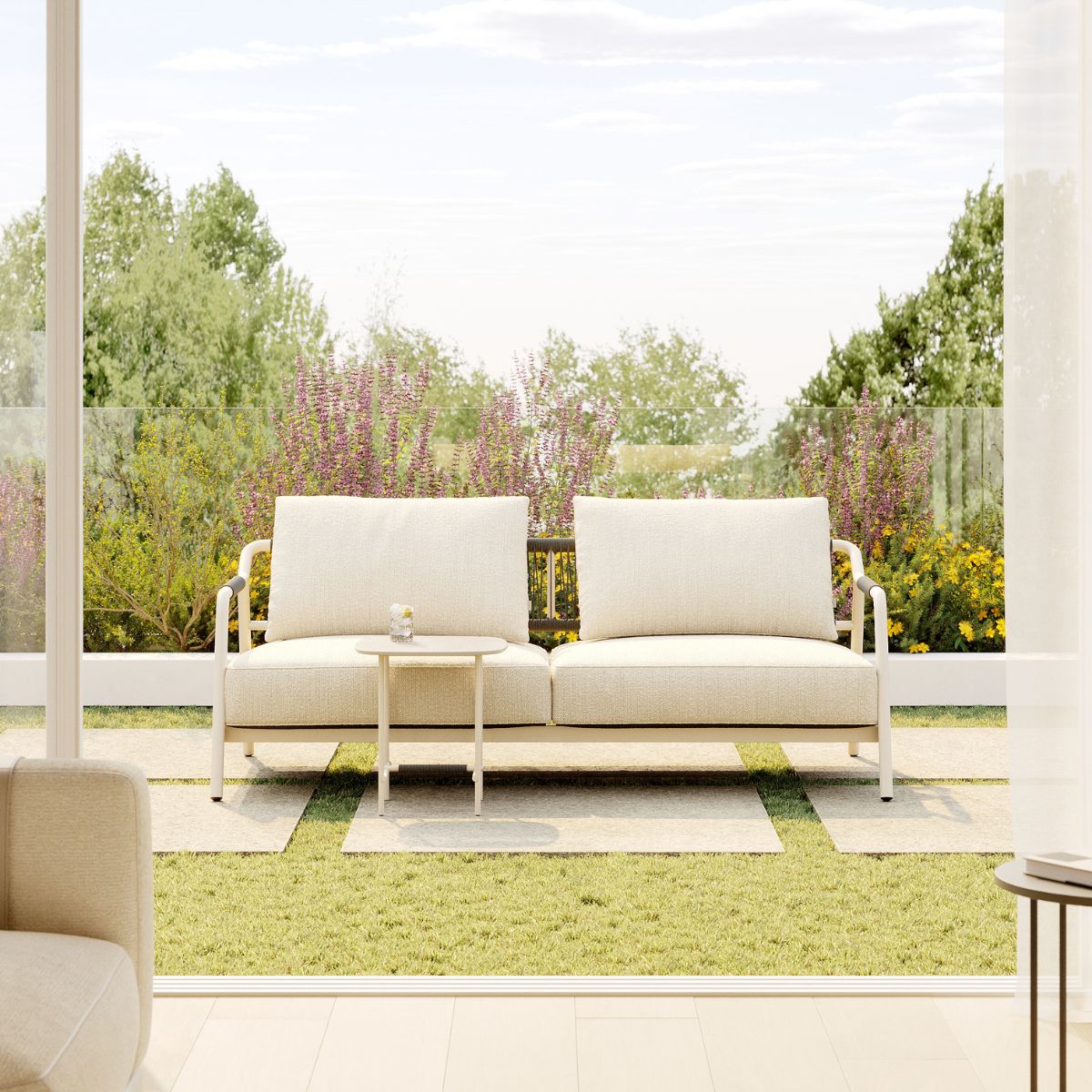 blog article about outdoor upholstery by domkapa (2) A modern outdoor area showcasing a white sofa, accented with neutral cushions and a sleek coffee table.