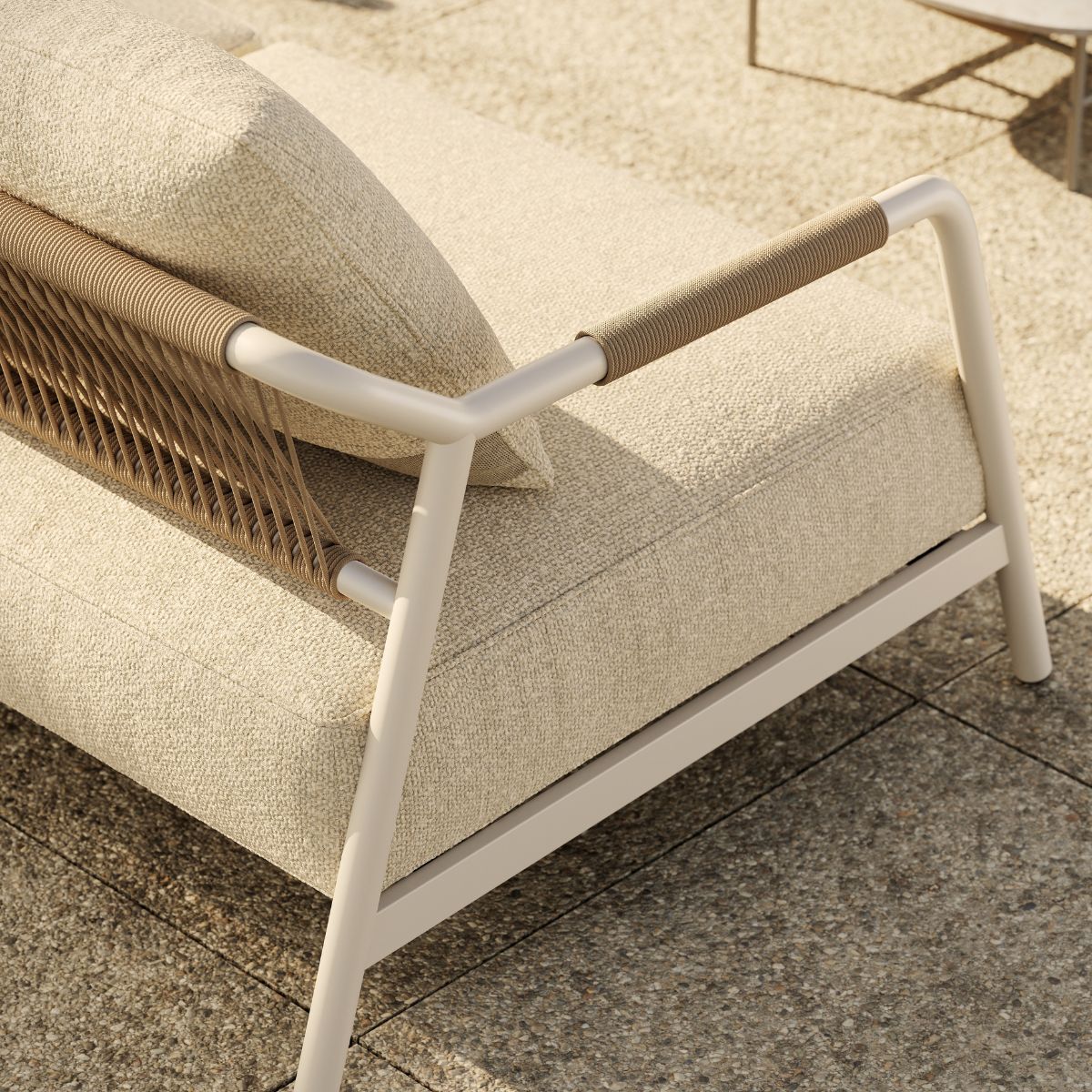 blog article about outdoor upholstery by domkapa (9) A white outdoor sofa with a brown frame positioned on a patio, surrounded by greenery and outdoor decor.