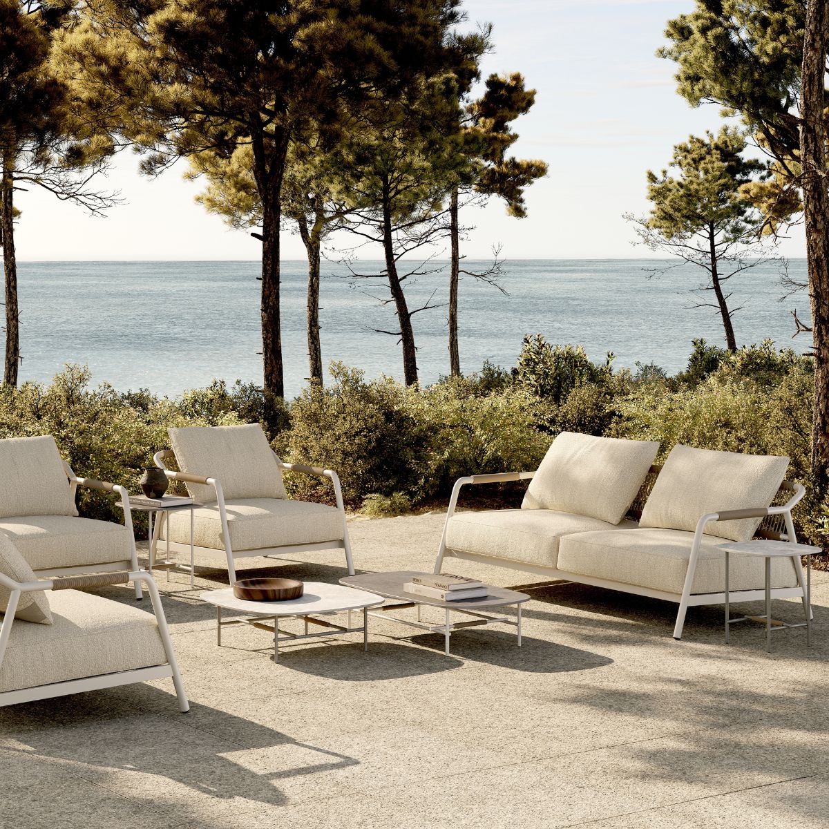 blog article about outdoor upholstery by domkapa An outdoor furniture set in white, consisting of a table and chairs, arranged on a concrete patio in a sunny environment. Outdoor upholstery