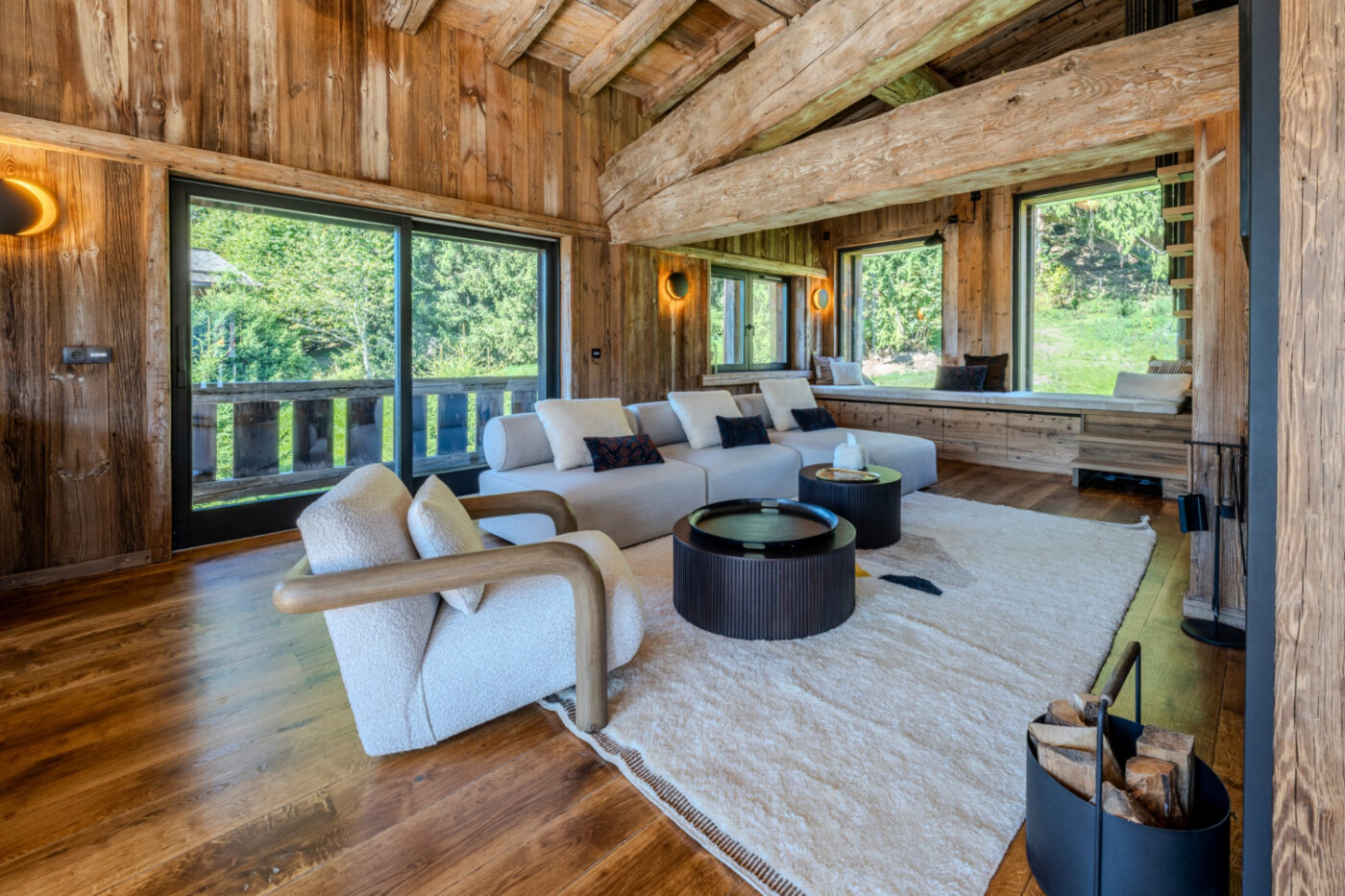 chalet project by aloona design A living room with rustic wooden walls and a fireplace, offering a comfortable and welcoming environment. By Aloona Design