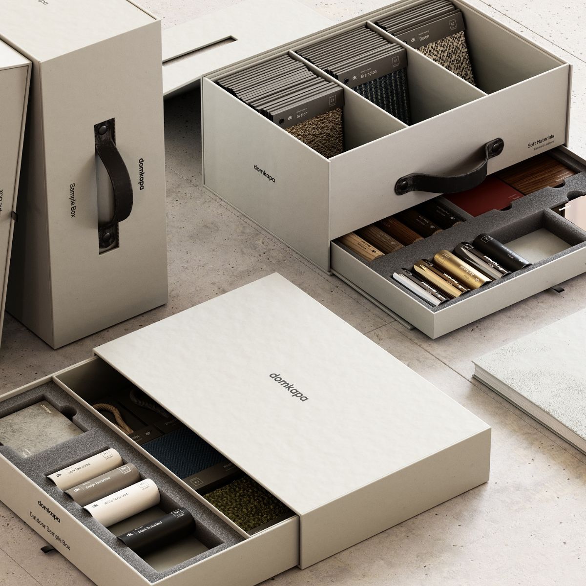 choose the perfect Domkapa sofa (4) A collection of sample boxes on a textured surface, showcasing organised fabric swatches, material samples, and colour palettes, conveying a sense of order and sophistication.