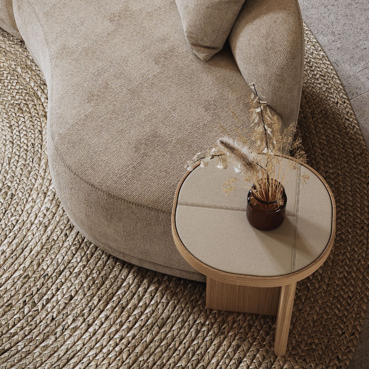 choose the perfect Domkapa sofa (5) A textured beige sofa curves around a small wooden side table holding dry foliage in a vase. A woven rug enhances the cosy, natural ambiance. How to choose the perfect sofa