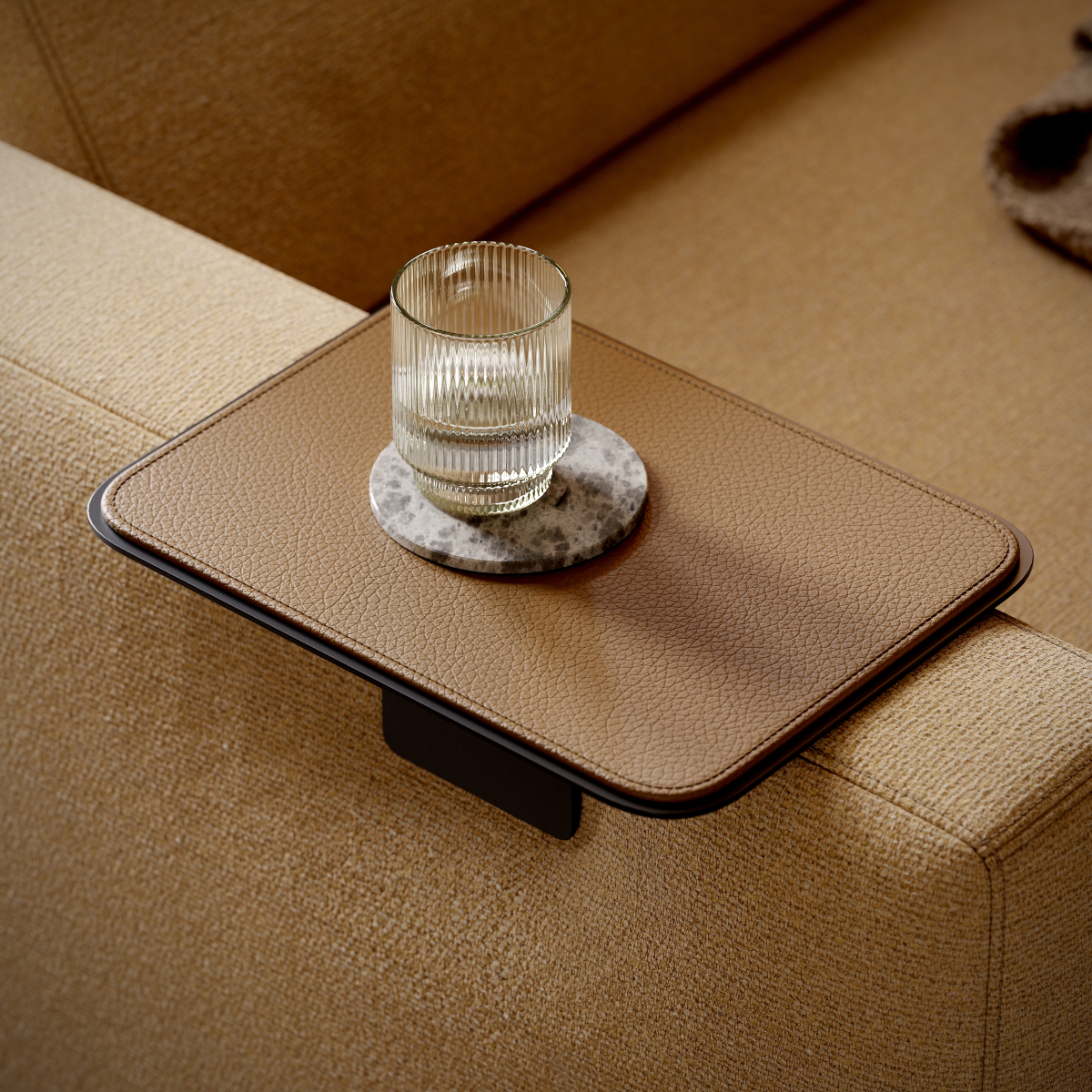 A glass of water placed on an armrest tray on a modular sofa, creating a serene and inviting atmosphere for relaxation.