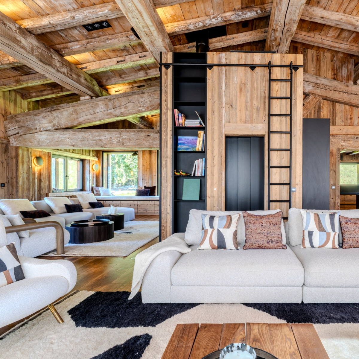 edward sofa and shinto sofa at aloona design project chalet A spacious living room showcasing a wooden ceiling and a comfortable white sofa, enhancing the room's elegance.