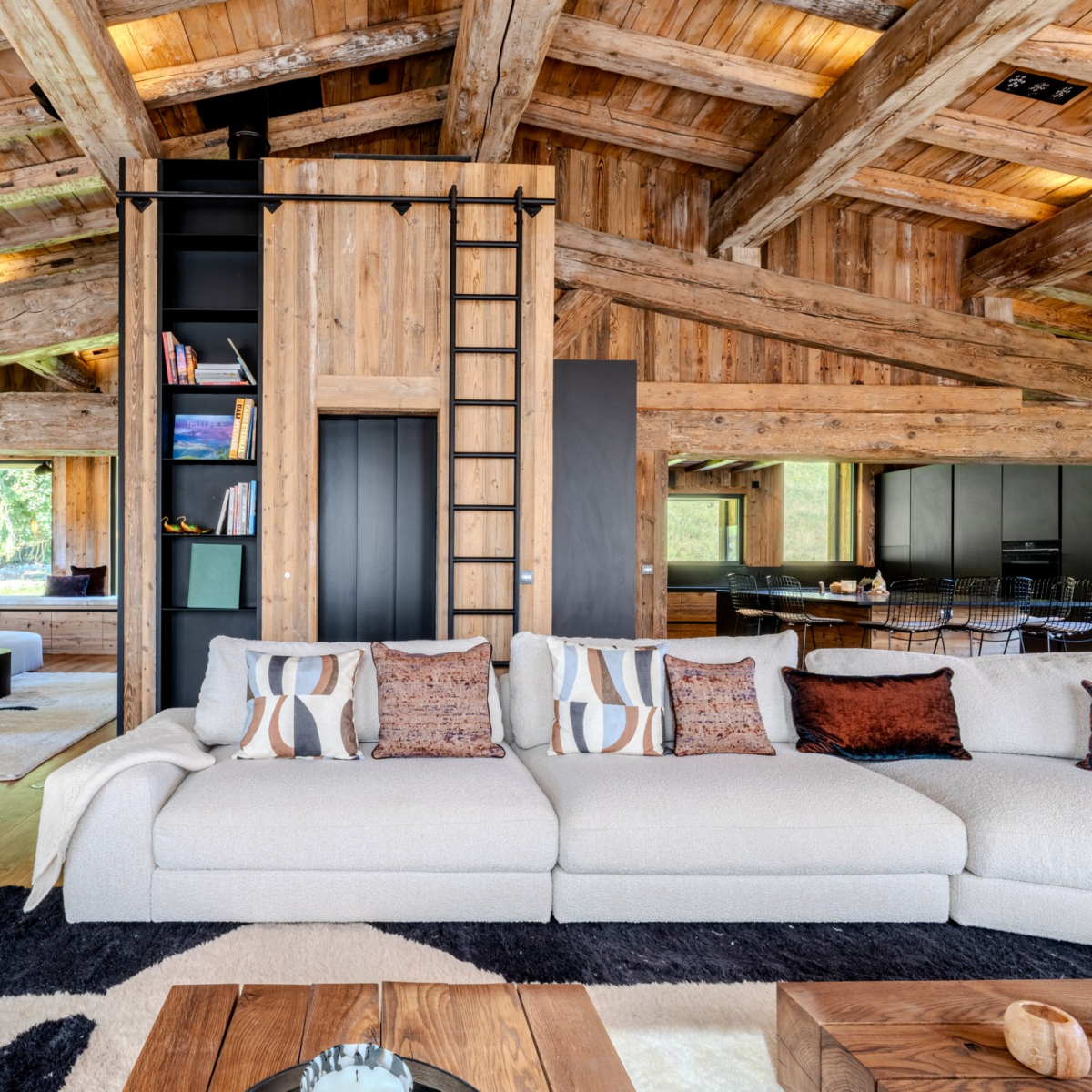 edward sofa at aloona design project chalet A spacious living room with a large modular sofa, enhancing the room's comfort and warmth. By Aloona Design.