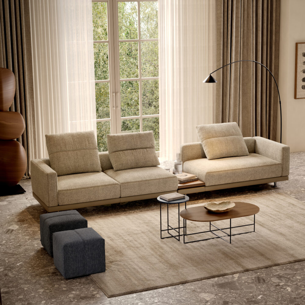 A modern living room showcasing a sofa, coffee table, and a pouf, designed for comfort and aesthetic appeal.