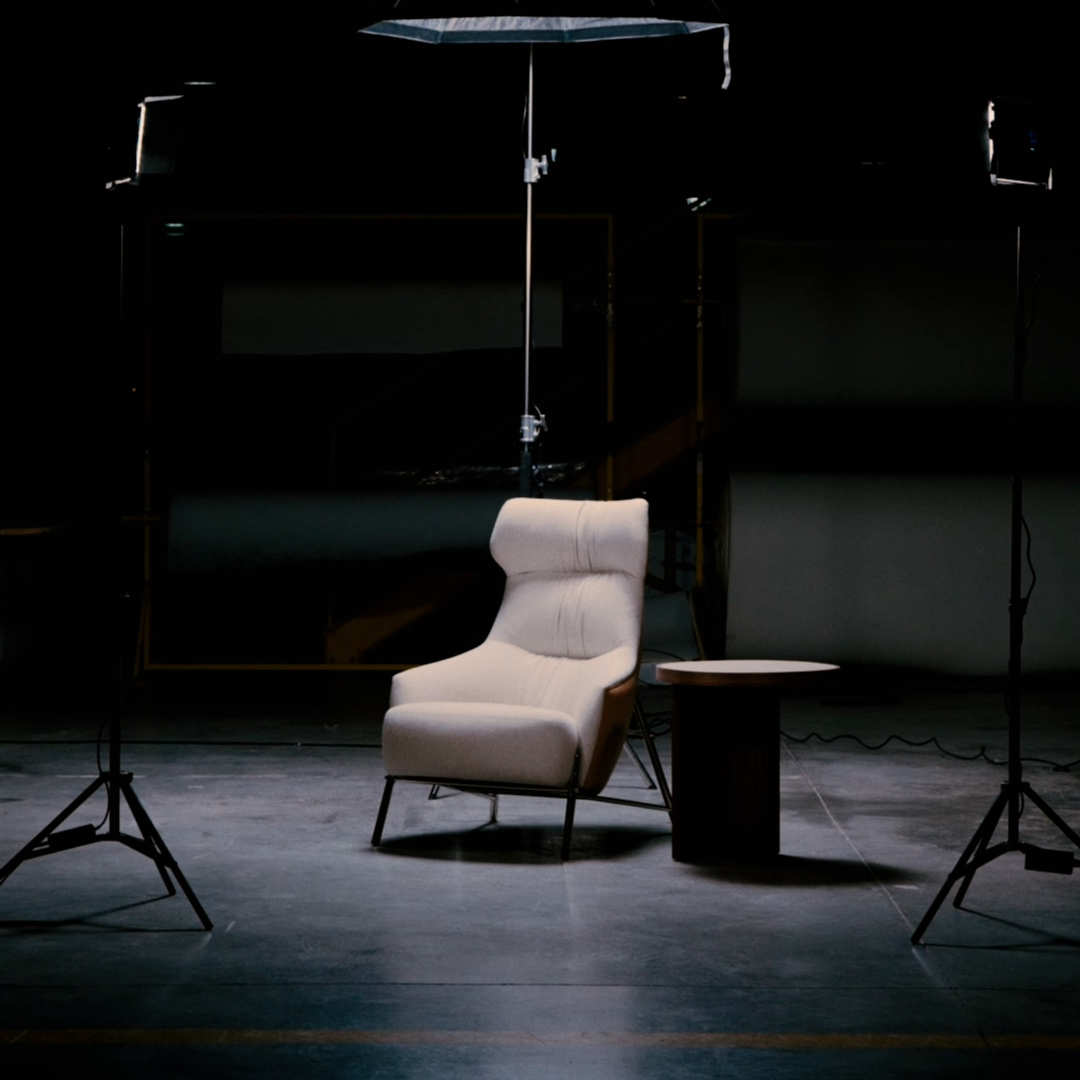 An armchair and a light stand are positioned in a dimly lit room, creating a moody atmosphere. Black Friday 2025.