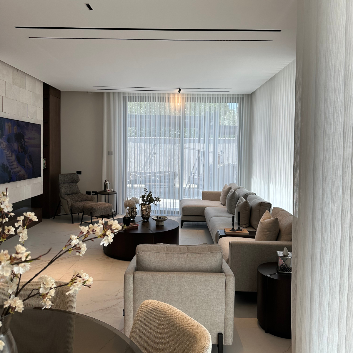 Contemporary living room showcasing a large flat screen TV, complemented by sleek furniture and a cosy atmosphere.