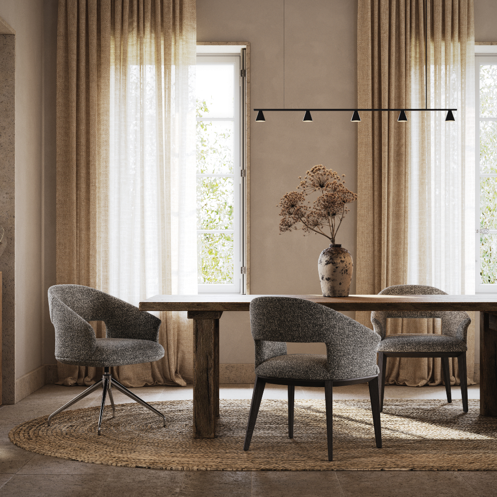 A bright dining room with a round table and four chairs, decorated with a centrepiece and natural light streaming in.