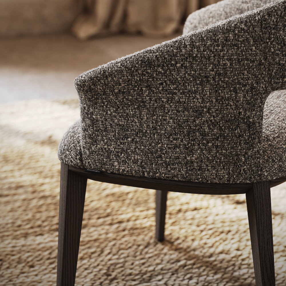 Close-up of a chair featuring a dark wood frame, highlighting its elegant design and craftsmanship.