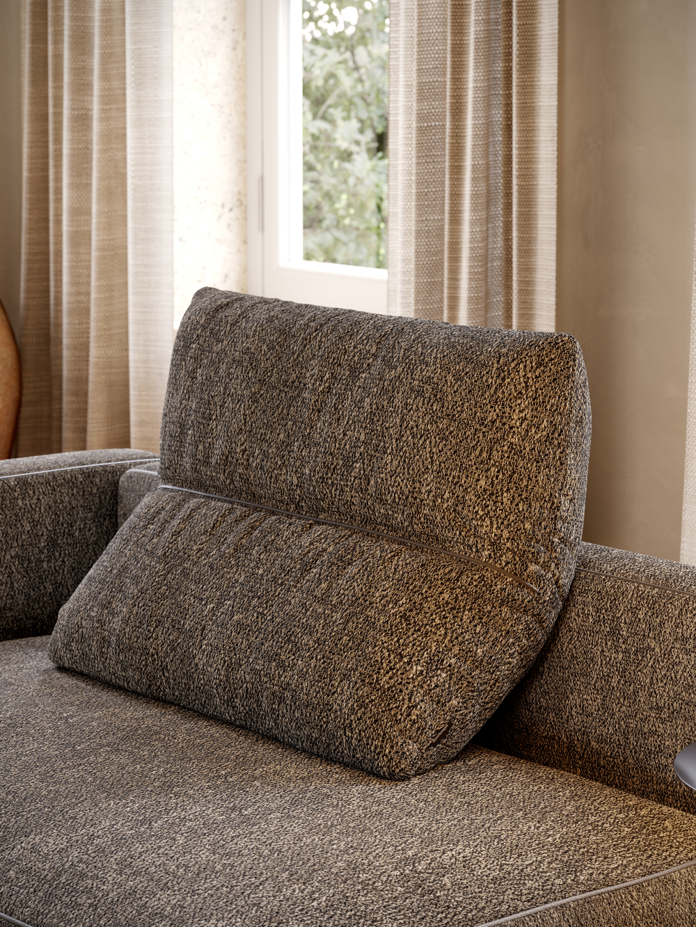 A comfortable modular sofa adorned with a pillow that is foldable, located in front of a large window.