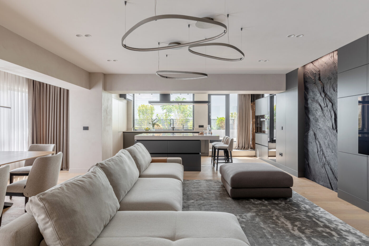 A modern living room featuring a stylish modular sofa and a sleek kitchen, creating a cosy and inviting atmosphere.